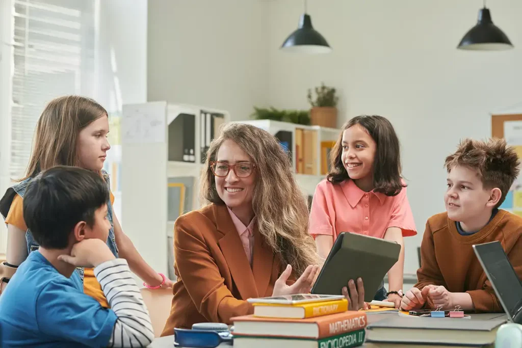 A teacher looking at books with a group of students.